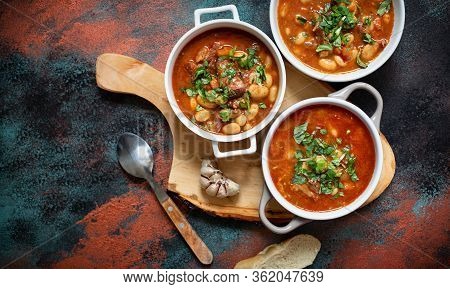 Bean Soup With Meat And Vegetables Served On A Rustic Board With Garlic. Traditional Balkan Soup Or 