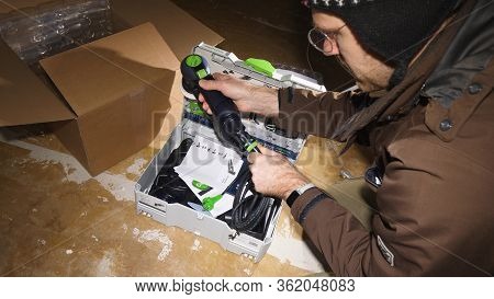 Strasbourg, France - Mar 3, 2020: Overhead View Of Worker Male Unboxing Parcel Containing New Best I