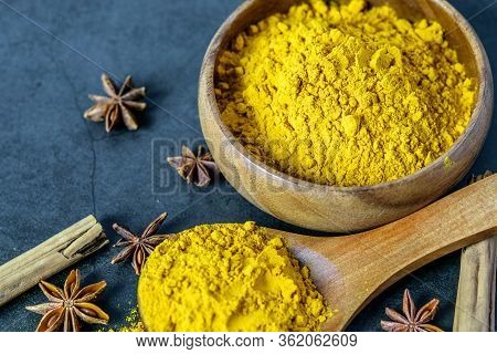 Turmeric Powderin Wooden Spoon And In Wooden Bowl, Cinnamon And Anise Closeup. Healing Spices, Healt