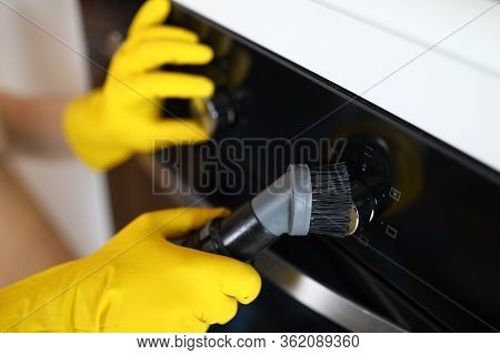 Hands In Rubber Yellow Gloves Brush Ceramic Panel. Steam Cleaner Brush To Remove Dirt In Oven. Clean