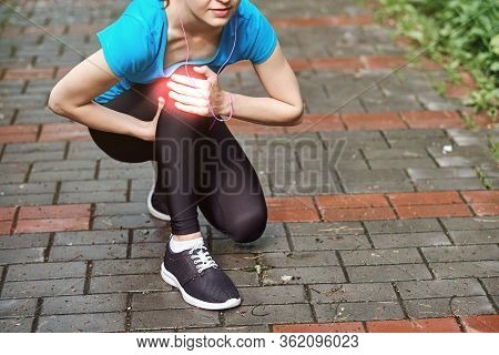 Woman Athlete Runner Touching Knee In Pain, Fitness Woman Running In Summer Park. Healthy Lifestyle