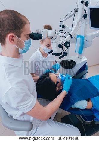 Treatment Of Root Canals Under A Microscope, Work With An Assistant.