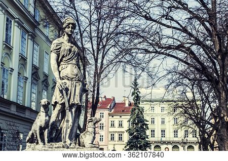 Monument To Diana With A Dog In The Center Of Lviv Square. An Old European City Photo.