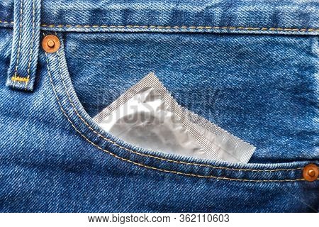 Two Condoms In Front Pocket Of Blue Jeans, Safe Sex Use Condom. Top Closeup View