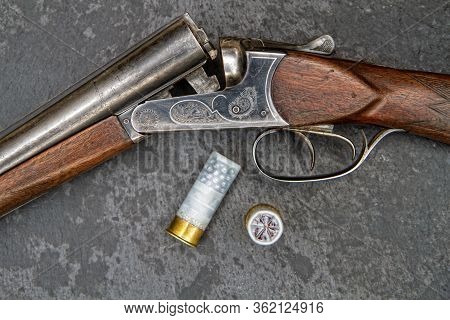 Old Classic Double-barreled Hunting Rifle Of The Twelfth Caliber And Cartridges For It On A Dark Bac