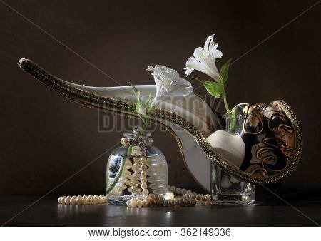 Retro Style Still Life With Beaked Venetian Carnival Plague Doctor Mask, Two Alstroemeria Flowers In