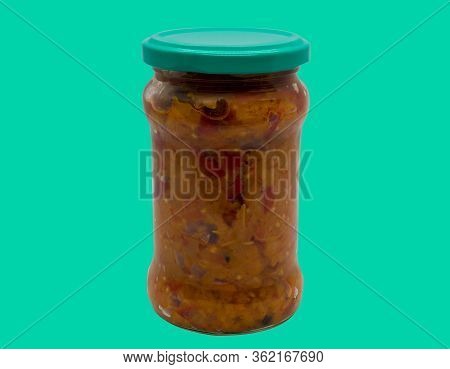 Traditional Romanian Mash Vegetables (zacusca) In A Glass Jar On A Green Background.