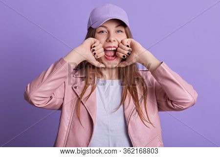 Picture Of Funny Joyful Young Female With Long Hair Opening Mouth Widely, Being In High Spirits, Wea