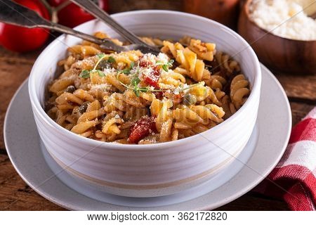 A Bowl Of Delicious Pasta Puttanesca With Rotini, Anchovies, Black Olives, Tomatoes And Capers.