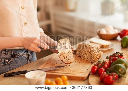 Warm-toned Close Up Of Unrecognizable Woman Making Sandwiches While Preparing Breakfast In Cozy Kitc