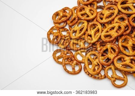 Salty Cracker Cookies In The Shape Of A Pretzel Sprinkled On A White Background. Oktoberfest Symbol 