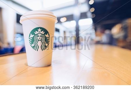 Bangkok, Thailand- July-20-2018 : Cropped Shot View Of A Paper Cup Of Starbucks Coffee On The Wooden