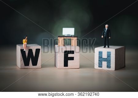 Miniature People Sit On Wood Blocks Of Wfh With Miniature Office Table. Concept Of Work From Home