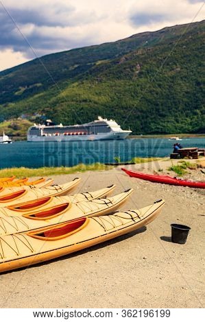 Kayaks On Shore And Cruise Ship On Fjord In Norwegian Tourist Destination Flam Village.