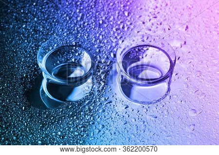 Contact Lenses, On Colorful Background. Two Contact Lenses With Water Drops On Pink-blue-green Backg
