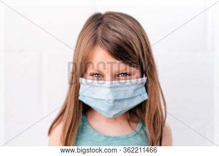 Portrait Of A Girl With Blue Eyes Wearing An Anti-virus Mask With Intense Assertive Positive Gaze Lo