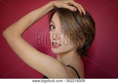 Young Woman With Short Hair Dressed In Black Lace Bustier And Blue Jeans Is Posing In The Studio On 