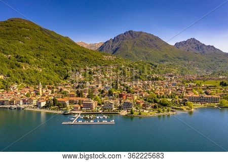Aerial View Of City Of Porlezza On The Shore Of Lake Lugano With The Alps In The Background Seen Fro