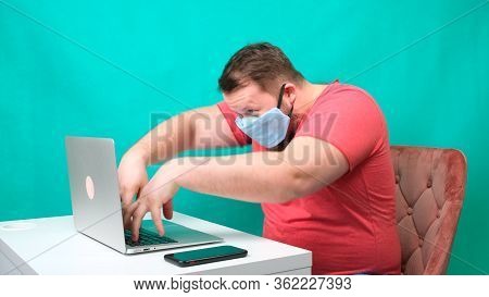 Masked Man Works Very Hard At The Computer While Being Quarantined Because Of The Virus. Funny Freak