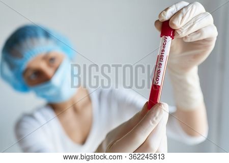 Doctor Or Laboratory Scientist In Face Mask And Glovs Holding Test Tube With Blood Sample For Covid-
