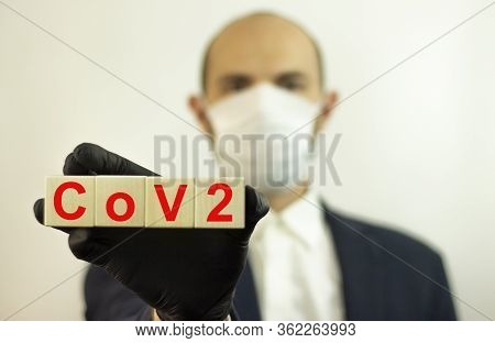 Stop The Infection Healthy Man Showing An Inscription On Wooden Cov2 Cubes. Photo Of A Man In A Prot