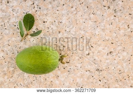 Closeup Of Ripe Feijoa Fruit With Leaves On Marble Kitchen Benchtop