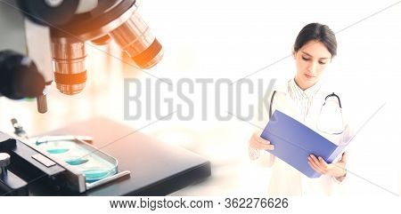 Female Doctor Review Patient Medical Data. Young Woman Physician With Stethoscope Standing And Serio