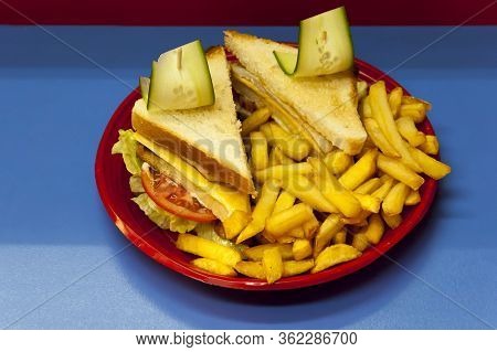 Portion Of Fast Food Serving With Roasted Potatoes, Yellow Cheese Sandwich Or Kashkaval And Fresh Ve