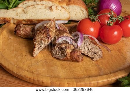 Meat Lyulya Kebab On Wooden Plate With Fresh Vegetables Close-up. Dish Of Georgian Cuisine