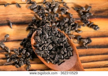 Dry puer tea leaf in wooden spoon on the rustick table