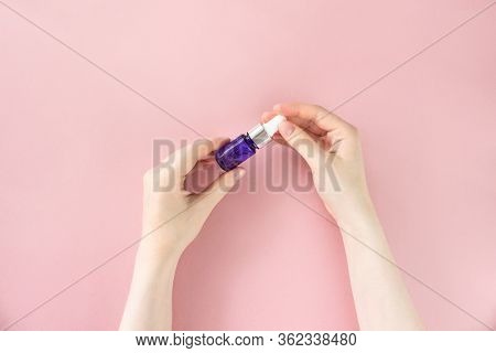 Blue Dropper Glass With Moisturizing Hyaluron Serum In Female Hands On Pink Background. Organic, Nat