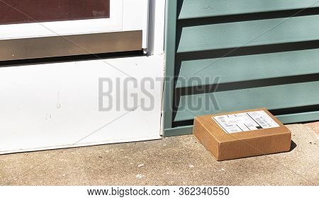 Babylon, New York, Usa - 1 April 2020: A Small Cardboard Package Is Deleverd And Left Out In View On