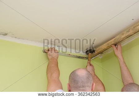 Fastening To The Wall Guide For Stretch Ceiling. Repairers Make Installation Of A Stretch Ceiling