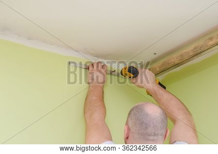 Fastening To The Wall Guide For Stretch Ceiling. Repairers Make Installation Of A Stretch Ceiling