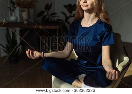 Young Woman Meditating In Armchair At Home. Young Women Meditating With Mudra Sign At Yoga Class Or 
