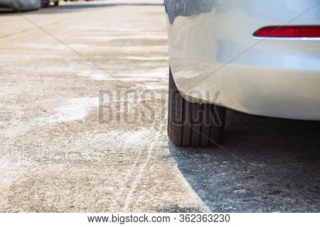 Close Up Bace Side A Car Tire Of A White Car Parking On The Village Road Under Sunlight For Along Ti