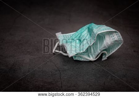 Infectious Waste Concept. Used Hygienic Face Mask Is Unhygienically Dumped On The Floor As Infective