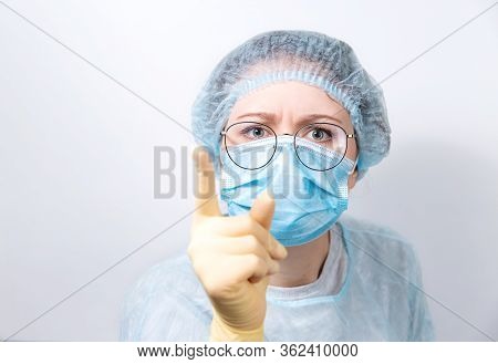 A Young Doctor In Uniform, Wearing A Protective Mask And Glasses Is Angry. The Doctor Swears That Pe