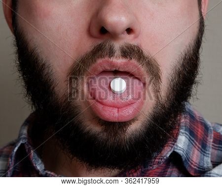 Portrait Of A Bearded Man Who Swallows A Tablet. Close-up Of The Tongue Of The Person On Whom The Ta
