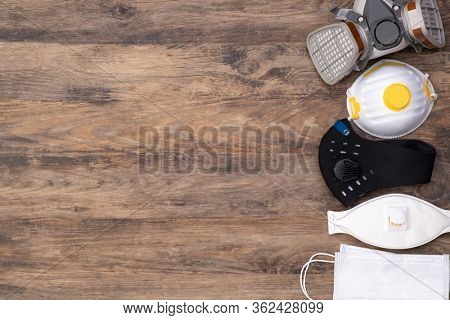 Different protective masks on wooden background, top view with copy space