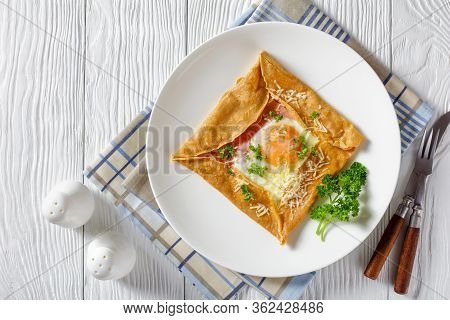 Breton Crepe, Savory Buckwheat Galettes Bretonnes With Fried Egg, Cheese, Ham Served On A White Plat