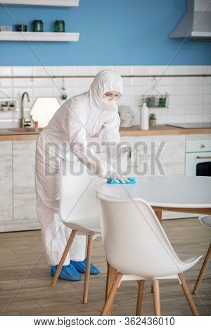 Woman In White Workwear Doing Disinfection In The Kitchen