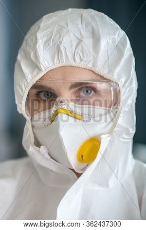 Woman In White Workwear And Protective Eyeglasses Looking Serious