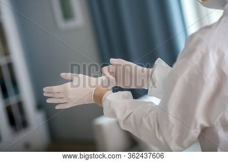 Person In White Workwear Wearing Protective Gloves
