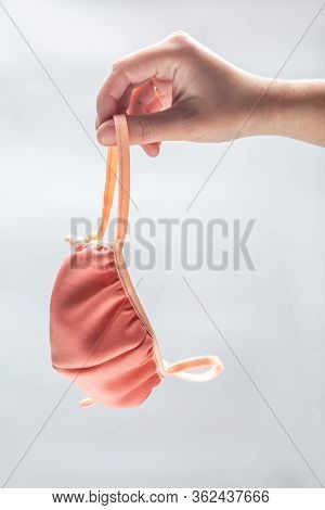 The Hand Holding A Handmade Beige Fabric Face Mask On A White Background. Vertical Orientation