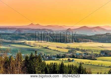 Hilly Landscape Illuminated By Evening Sunset. Green Grass Fields And Hills On The Horizont. Vivid S