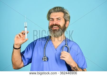 Coronavirus Epidemic From China. Mature Doctor Use Syringe In Hospital . Skilled Nurse Make Injectio
