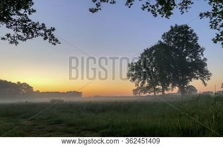 Dramatic And Colorful Sunrise Sky. Dramatic And Colorful Sunrise Or Sunset Sky Over A Grassy Green F