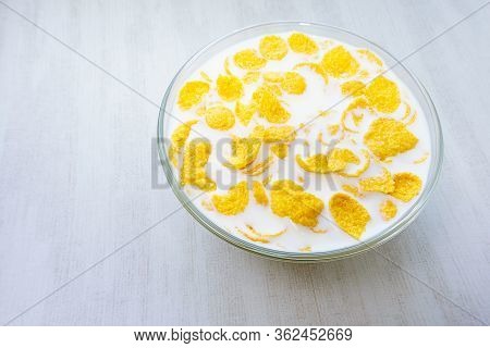 Breakfast Corn Flakes. Milk Into Bowl Of Corn Flakes Background, Top View. Healthy Breakfast. Food A