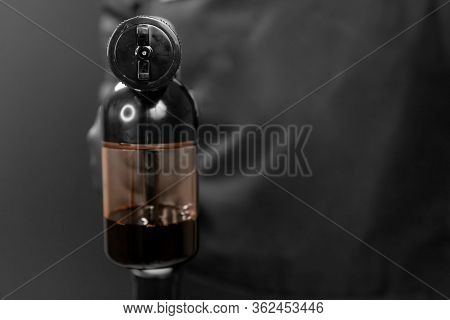 Master Holds Airbrush For Instant Tanning Tan Spray Body Paint On Black Background In Professional B